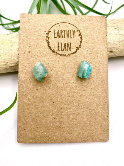 Pair of blue apatite gemstone stud earrings set in sterling silver on a jewelry card, showcasing a minimalist and elegant design.